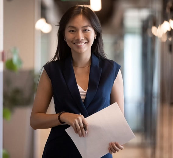 A professional woman in a business suit confidently holds a piece of paper, ready to tackle her workday.