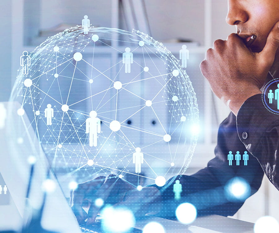 A person interacts with a laptop, surrounded by a digital globe and graphics representing connectivity and networking.