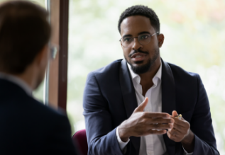 Two men in business suits talking to each other.