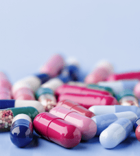 A group of generic pills on a blue surface.