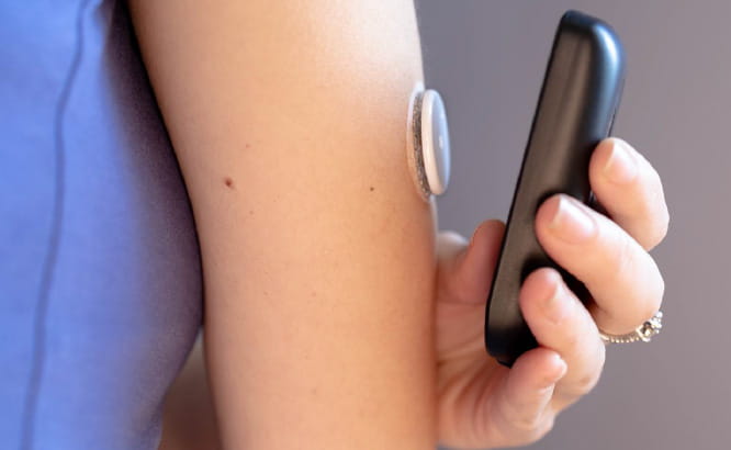 Patient using a medical device to check for blood sugar level.