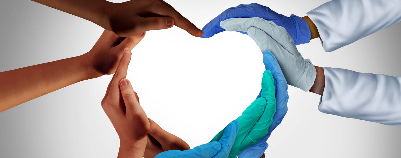 Hands of patients and healthcare providers together forming a heart.