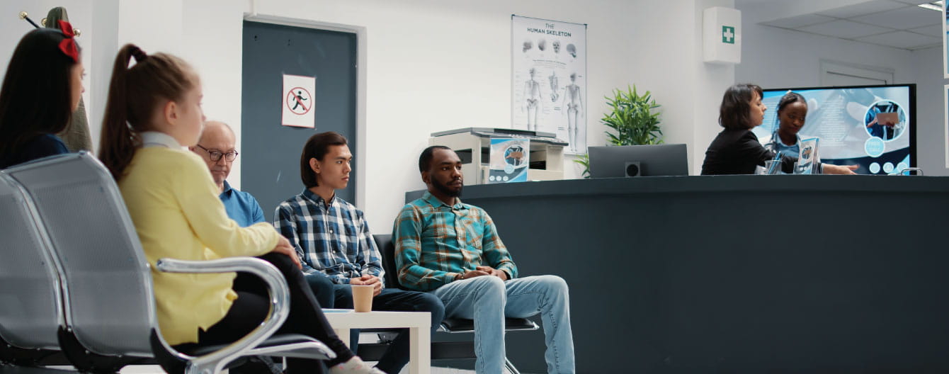 A diverse group of people sitting in a waiting room together.