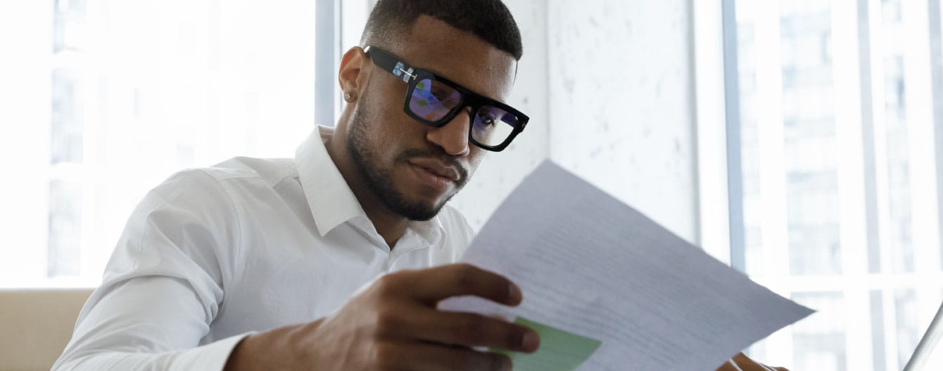 Person with glasses looking at paperwork.