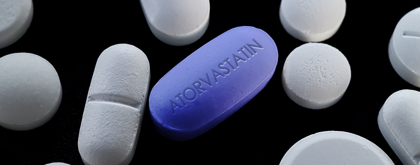A blue pill with atorvastatin text on it.
