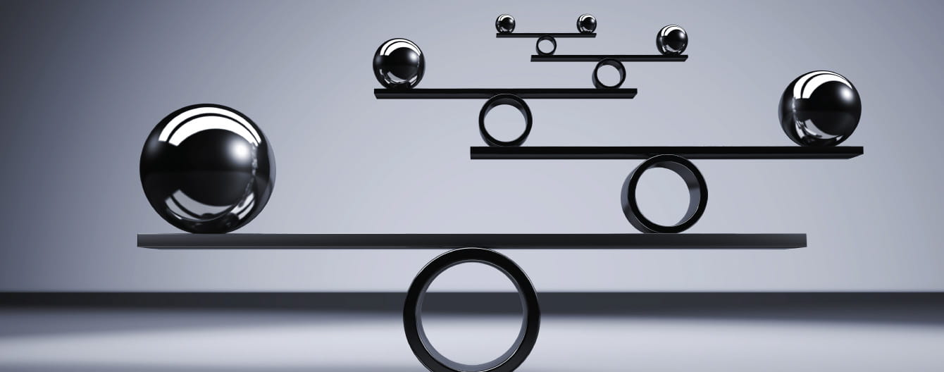 Three spheres of different sizes balanced on beams, showcasing harmony and equilibrium.