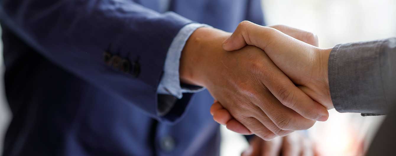Two people shaking hands after a partnership agreement between Citeline and Greenphire.