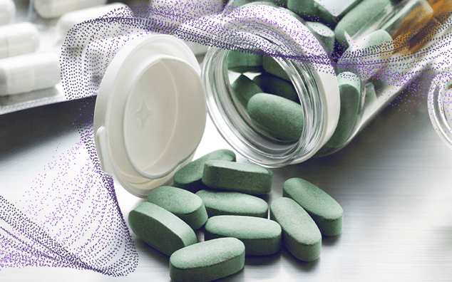 A variety of pills and tablets arranged neatly on a wooden table surface