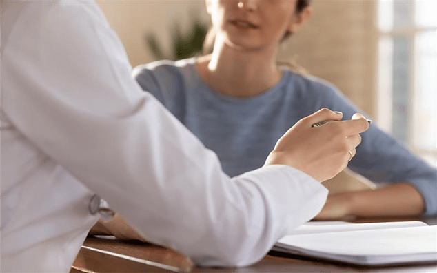 Focused doctor explaining medical insurance benefits or health treatment protocol.