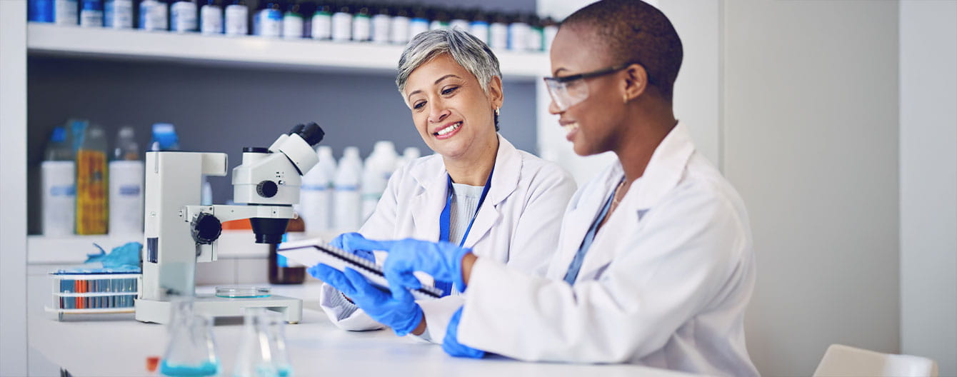 Happy female scientists planning microbiology investigation, feedback and review paperwork