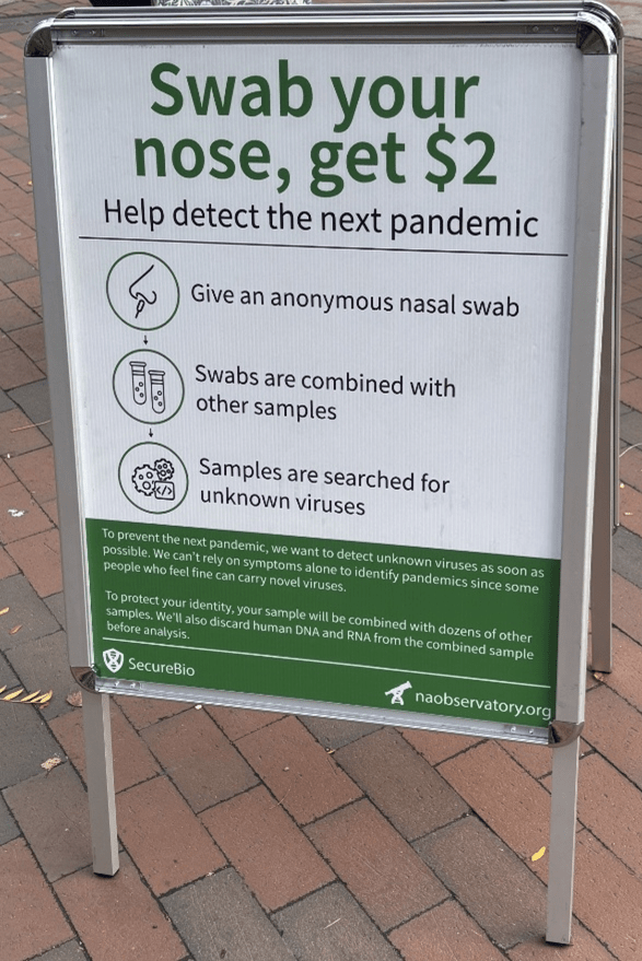 A sign offering $2 for an anonymous nasal swab to help detect unknown viruses.