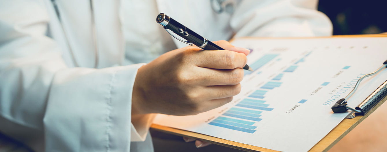 A medical professiona reviewing and signing medical reports related to healthcare.