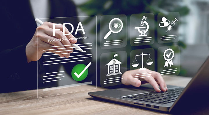 Person using a laptop and stylus with FDA approval and medical research icons floating on screen.