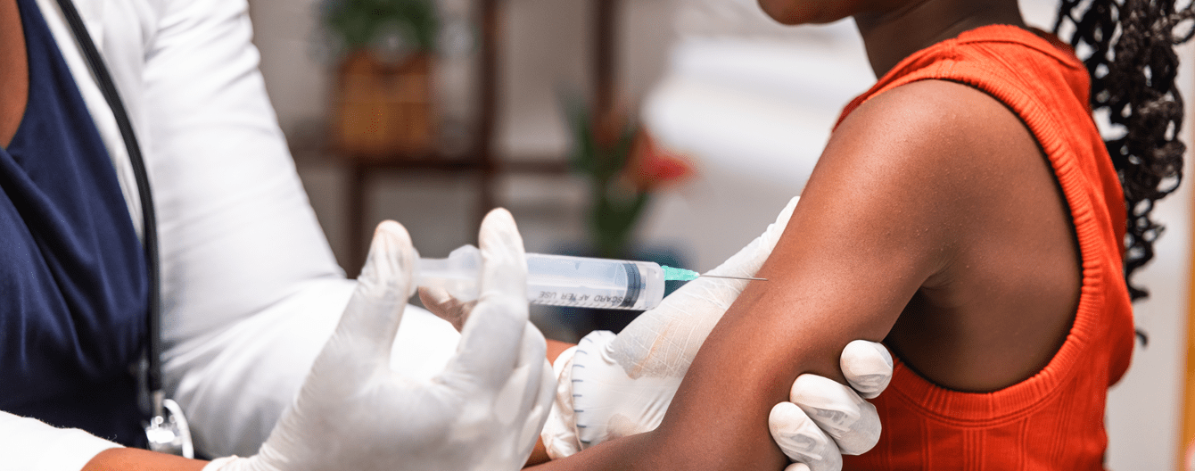 A close up image of an African girl child receiving vaccination from pediatrician in medical office.