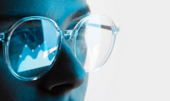 A person wearing glasses, looking at a graph displayed on the screen.