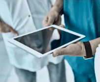 Healthcare professionals collaborating around a tablet device.